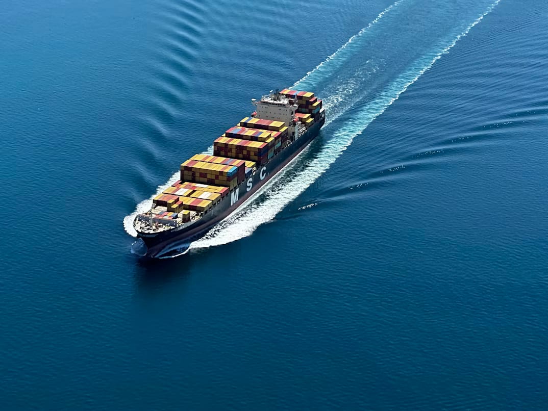 Cargo ship seen from above at sea, representing foreign companies importing goods into Rwanda